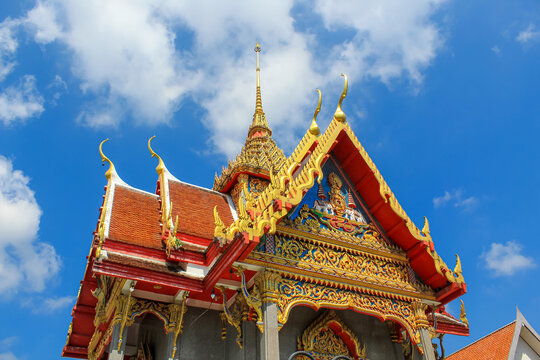 Horizontal image of the roof of the Thai buddhist temple in Phuket, Thailand. Blue sky, copy space for text, wallpaper, golden, red, green, blue