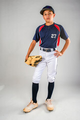 Male youth baseball player with glove standing with his hand on his hip