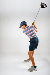 Young male golfer swinging club about to hit the ball