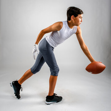 Male youth football player handing off the ball