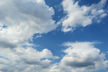 Naklejka na ściany i meble Beautiful white fluffy clouds in blue sky background