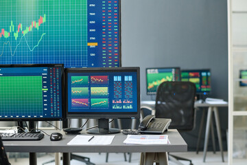 Horizontal no people shot of modern stock and currency trading specialists workspace desktop computers and computer monitors in modern office
