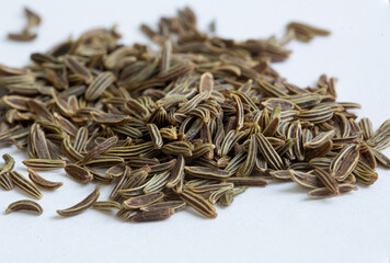 A pile of cumin seeds , macro close up, this is a popular spice through out India and the middle eastern cuisines.
