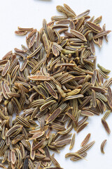 A pile of cumin seeds , macro close up, this is a popular spice through out India and the middle eastern cuisines. top down