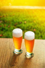 Cerveja 2 copos chopp em dobro Cerveja em base de madeira com fundo de natureza verde