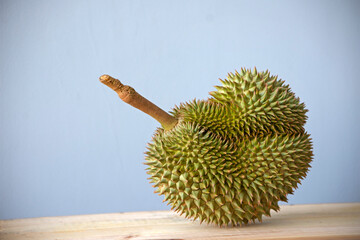 Durian on wooden table against flat color background - 506540586