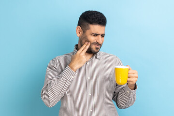 Portrait of upset bearded businessman suffering from terrible teeth pain after drinking hot or cold...