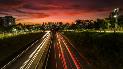 Trail of light caused by vehicular traffic in SP-294, Comandante Joao Ribeiro Barros Highway with buildings from downtown in the background, in Mar&iacute;lia,
