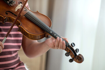 Indian boy hands playing the violin, close up, selective focus