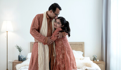 Loving Indian daddy and little adorable daughter hugging  in bedroom at home, fathers day concept