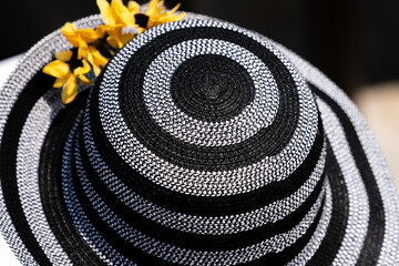 A women wearing a black and white hat at a horse race.