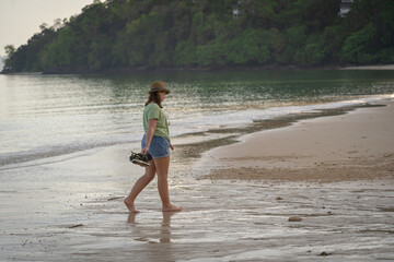 Young Caucasian Girl wearing summer clothes walking on the beach. Langkawi, Malaysia