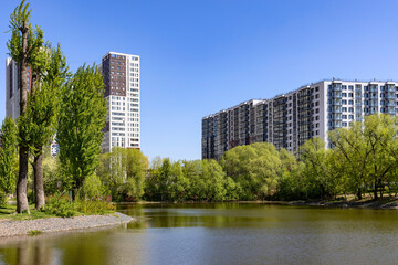 Fototapeta na wymiar New modern residential district with apartment buildings near the lake surrounded by green trees park