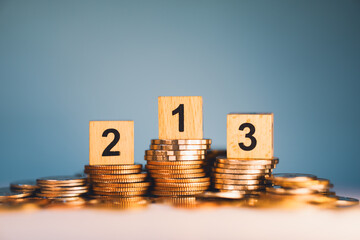 Wooden block number on stack coins using as business development and financial concept
