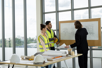 Fototapeta premium Team of male and female engineers and architects, working team, meeting, discussing construction and drawing construction plans, printing, writing on-site construction sites
