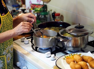 The process of cooking pies. The woman on the stove fries pies. Healthy homemade food concept.