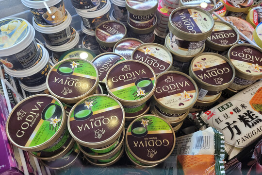 PENANG, MALAYSIA - 30 APR 2022: Various choices of Godiva ice cream imported from Japan display on freezer shelf in a grocery store Penang. Soft focus image.
