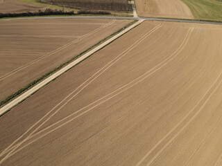 Fototapeta premium Aerial view of freshly plowed agricultural fields in spring
