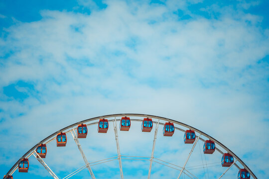 Cabins of ferris wheel against blue sky; close up