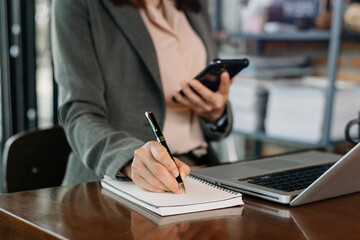 Fototapeta premium businesswoman hand working with new modern computer and writing on the notepad strategy diagram