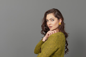close-up portrait of beautiful sensual female with long curly hair against gray background