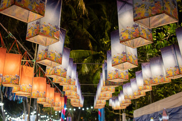Lanterns decorated with marine animal motifs, purple, orange, several at night.