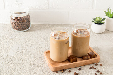 two modern glasses in the shape of a can of cold latte coffee, a chocolate drink or mocha on a...