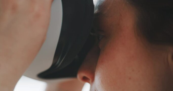 Close up shot of female eyes putting virtual reality goggles on