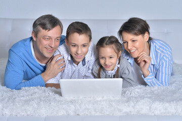 Smiling family looking at a laptop