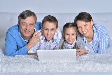 Smiling family looking at a laptop