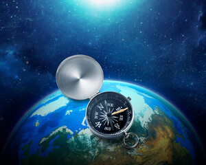 Compass nestled on blue earth in space colorful solar system. . Travel destination and navigation concept around the world