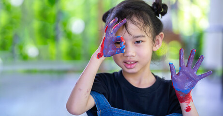 Little cute girl showing painted hands ,Portrait of a cute cheerful girl have fun painting her hands. Showing painted hands with copy space