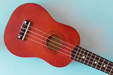 Fototapeta premium Musical instrument. Ukulelle on a blue background close-up