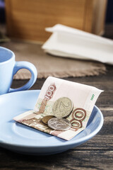Restaurant tips or gratuity, russian banknotes and coins on plate