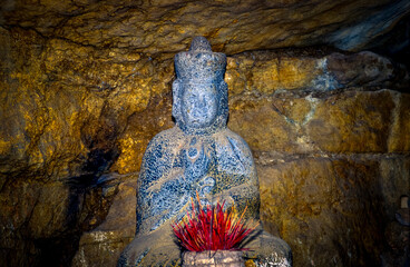 Eingescanntes Diapositiv einer historischen Farbaufnahme in einer Höhle mit Buddhafiguren in einem...