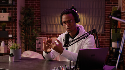 African american vlogger streaming live internet show using digital video camera for social media...