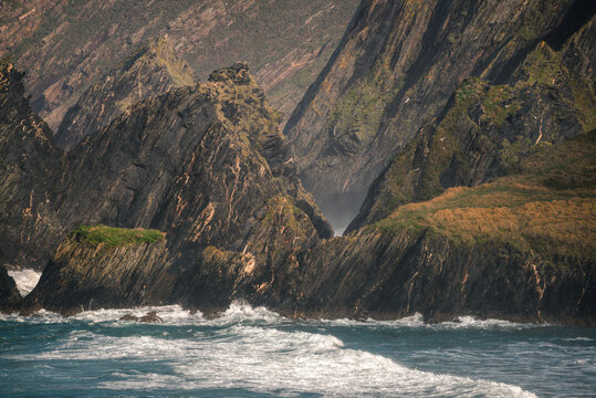 High cliffs of dark slate with veins of golden pyrite