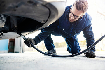 A car service worker checking on car exhaust gases on technical service.