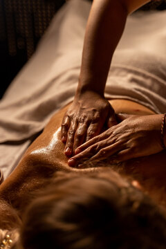  Thai massage at the spa. the masseur's hands are close-up doing an oil massage on a woman's body