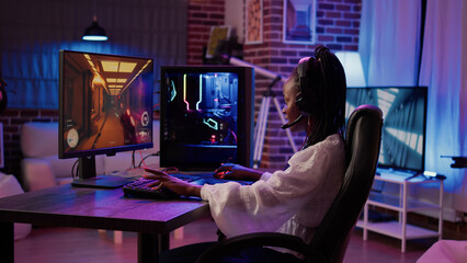 African american gamer girl streaming first person shooter tournament surprised after winning online competition on gaming pc at home. Woman playing action game happy with game progress results. © DC Studio