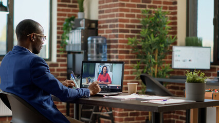 African american worker meeting with businesswoman on online video call, using teleconference chat to have remote conversation. Talking on virtual internet webcam videoconference.