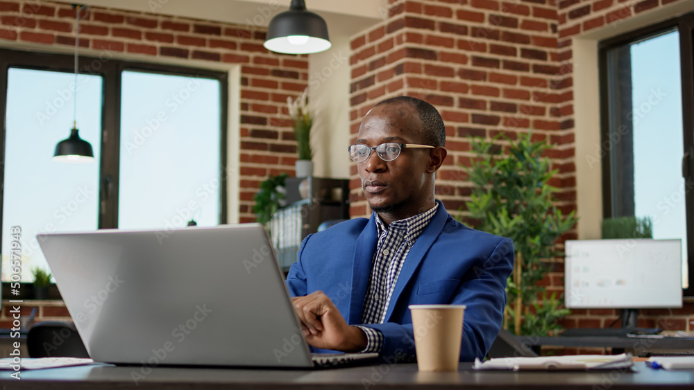 Wall mural company employee writing business report on laptop, typing research information on internet browser.