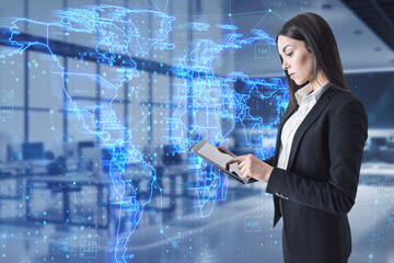 Attractive young european businesswoman using tablet with glowing blue map hud screen and digital data concept on blurry office interior background. Info, news and planet. Double exposure.