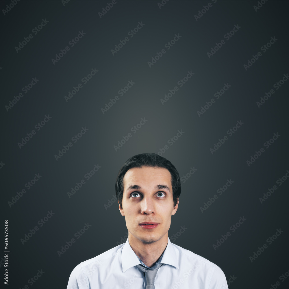 Poster man looking up in white shirt and tie isolated on blank dark grey background with empty space for yo