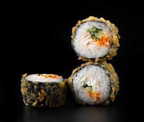 fried rolls with crab and cucumber on black background
