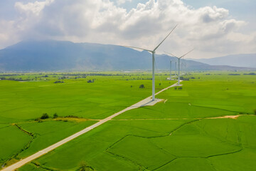 PANORAMIC VIEW OF WIND FARM OR WIND PARK, WITH HIGH WIND TURBINES FOR GENERATION ELECTRICITY WITH COPY SPACE. GREEN ENERGY CONCEPT ON RICE FIELD AT NINH THUAN, VIETNAM