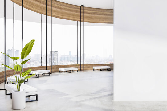 Blank white wall part in sunny round spacious office hall waiting area with black and white benches, wooden window decoration, city view from window and glossy concrete floor. 3D rendering, mockup