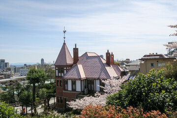 Fototapeta na wymiar 風見鶏のついた屋根の館と春の景色