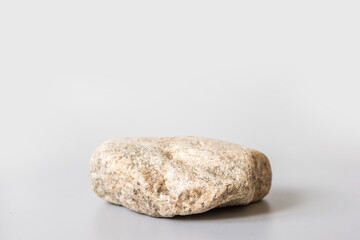Natural stone stand for presentation and exhibitions on pastel gray background. Abstract podium for organic cosmetic products. Minimal style.