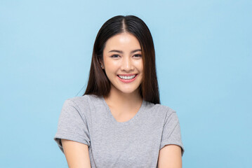 Portrait of pretty southeast Asian girl smiling in light blue color isolated studio background